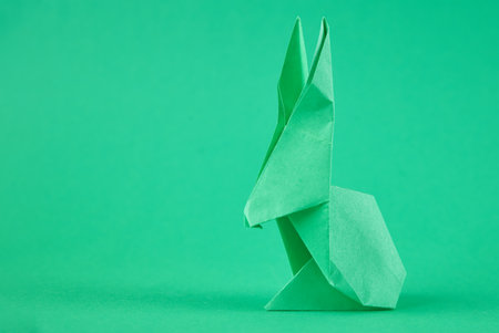 Paper origami Esater rabbit on a green background. Easter celebration conceptの写真素材