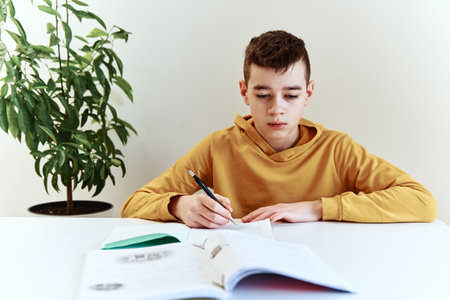Teenage boy write homework at home. Education conceptの写真素材