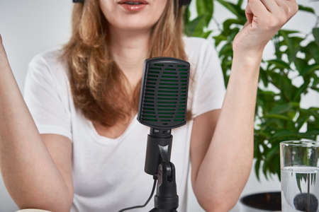 Woman recording online podcast at home. Microphone on table. home studio workplaceの写真素材