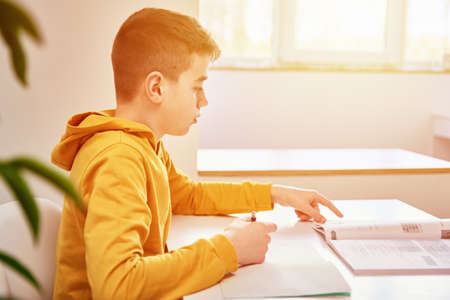 Teenage boy write homework at home. Education concept