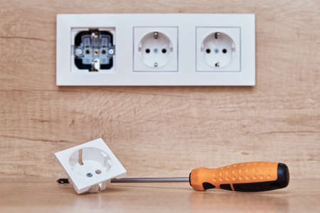 Broken socket and screwdriver on the table. Installing electrical socket i thekitchenの写真素材