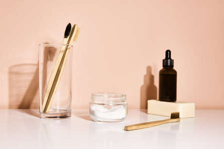 Bamboo toothbrushes and tooth paste on pink background. Reuse natural productsの写真素材