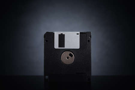 Floppy disk on dark background. Retro computer disketteの写真素材
