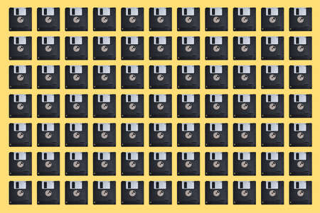 Pattern with many floppy disks on yellow background. Retro computer disketteの写真素材