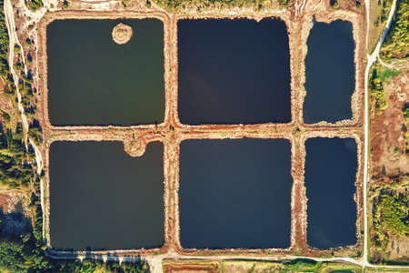 Aerial view of ponds for collect stormwater. Rainwater retention basins, bird eye view. Artifical pools for irrigation systemの写真素材