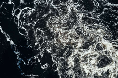 Waves of water in the river with whirlpool, aerial view. Water background. Abstract pattern of water...