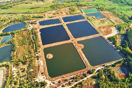 Aerial view of ponds for collect stormwater. Rainwater retention basins, bird eye view. Artifical pools for irrigation systemの写真素材