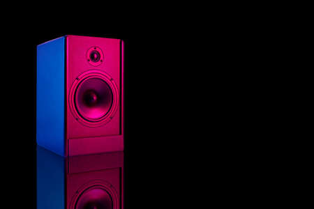 Neon colored stereo speaker on dark background with reflection.Sound audio loud speaker with copy spaceの写真素材