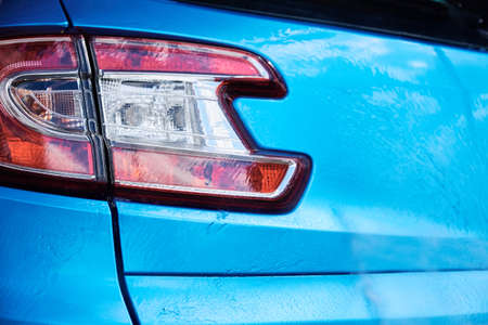Car washing. Soap water running off from a washed blue car. Close up of part of modern carの写真素材