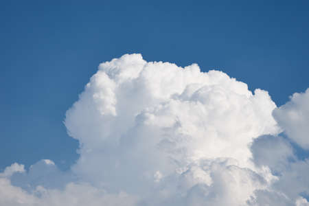 Big white fluffy clouds on clear blue sky. Cloudy sky background with copy space. Cumulus cloud close upの写真素材