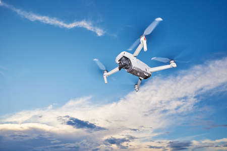 Modern drone with camera in the sky. Flying quadcopter