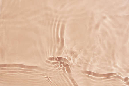Beige water surface background. Water texture with splashes and bubbles. Summer nature background