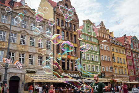 Street performer makes big bubbles on city street to entertain children and tourists in Wroclaw, Poland. Wroclaw, Poland - July 25, 2021のeditorial素材
