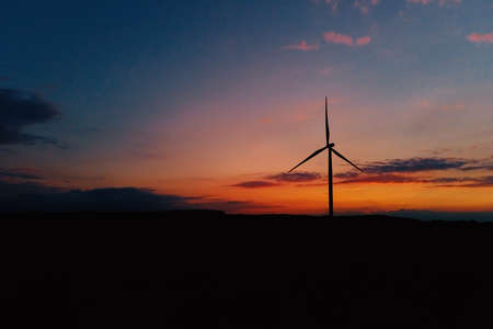 Windmill silhouette at sunset sky. Wind turbine generator. Wind energy concept. Suistanable and renewable energy for climate protectionの写真素材