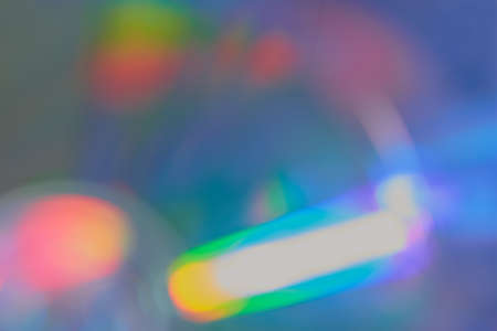 Defocused film texture background with colored lights on dark background. Blurred rainbow color light flare for photo effectsの写真素材