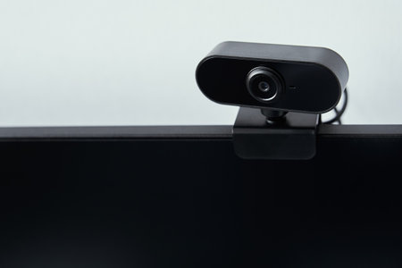 Webcam above computer screen. Black webcam above black screen. Digital security conceptの写真素材