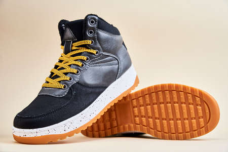 Pair of male shoes on beige background. Black stylish boots, close upの写真素材