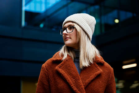 Portrait of beautiful woman in eyeglasses. Woman wearing coat at city. Street walkingの写真素材