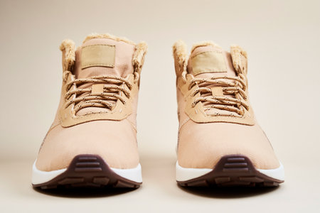 Male boots on beige background. Pair of winter stylish leather shoes, front viewの写真素材