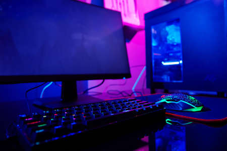 PC with rgb keyboard for gaming computer video games with neon colored background, dark room with...