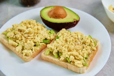 Toasts with avocado and egg on white plate, Healthy food and dieting concept, Organic productの写真素材