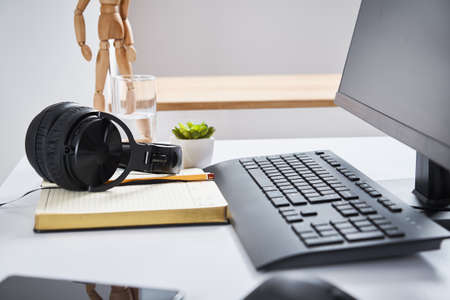 Remote workplace for freelance work, Online education at home, Table woth computer monitor, keyboard and headphonesの写真素材