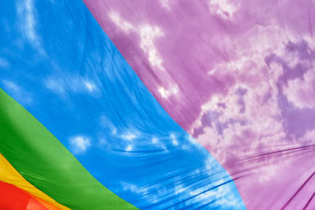 LGBTQ rainbow flags on pride parade against sky. Tolerance, diversity and gender identity concept