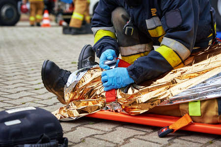 Rescuers provide first aid to the victim during a car accident. Person injured in the accident is...