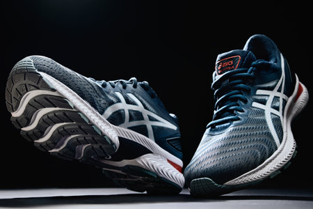 Flying Asics Gel Nimbus shoes on black background, Creative shot of Asics sport sneakers for jogging. Katy Wroclawskie, Poland - August 07, 2022のeditorial素材