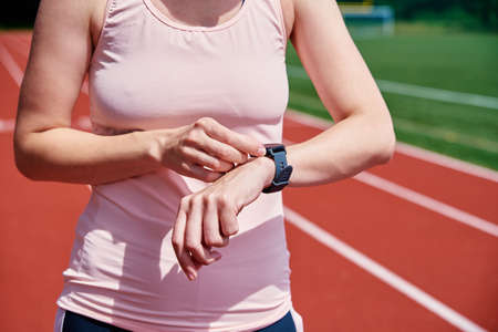 Woman use fitness watch before cardio exercises, Checking results on smart watch after training, Healthy lifestyle conceptの写真素材