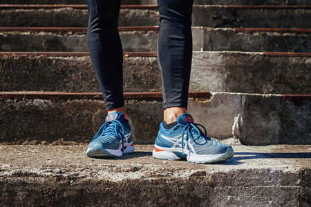 Male sprinter wearing Asics Gel Nimbus at concrete stairs background. Sport and fitness runner athlete training at stadium. Katy Wroclawskie, Poland - August 07, 2022のeditorial素材