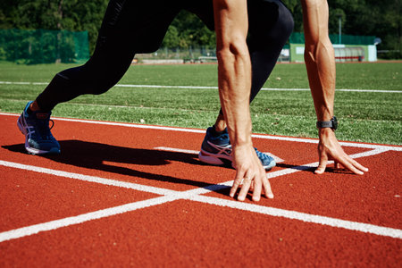 Male sprinter wearing Asics Gel Nimbus waiting for start at running track. Sport and fitness runner athlete training at stadium. Katy Wroclawskie, Poland - August 07, 2022のeditorial素材