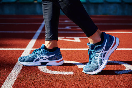 Male sprinter wearing Asics Gel Nimbus at running track. Sport and fitness runner athlete training at stadium. Katy Wroclawskie, Poland - August 07, 2022のeditorial素材