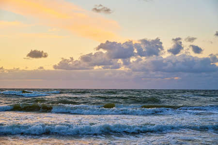 Sea sand beach landscape. Seascape background. Sunset sky over ocean water surface with calm waves,...