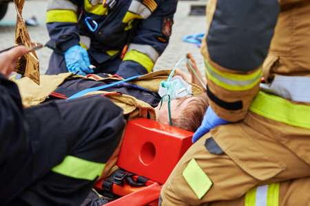 Rescuers provide first aid to the victim during a car accident. Person injured in the accident is lying on the road. Katy Wroclawskie, Poland - May 28, 2022のeditorial素材