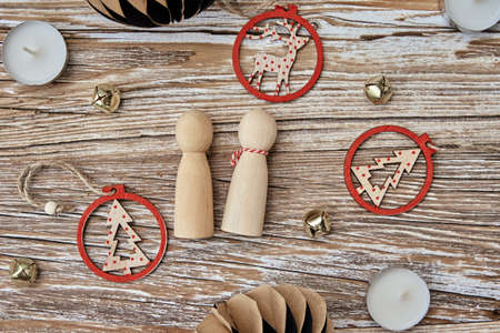 Couple made of wooden toy people and chritmas decoration on wooden background