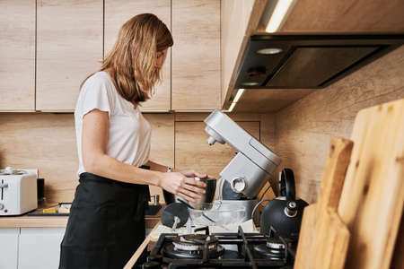 Woman cooking at preparing food, using food processor, Modern appliance for cookingの写真素材