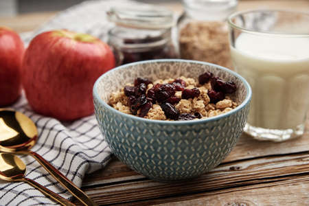Granola with milk in blue bowl on wooden table, Healthy organic breakfast with muesli, Food clean eating conceptの写真素材