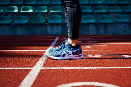 Male sprinter wearing Asics Gel Nimbus at running track. Sport and fitness runner athlete training at stadium. Katy Wroclawskie, Poland - August 07, 2022のeditorial素材