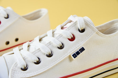Female Big Star sneakers against yellow background, Casual trendy shoes closeup, Creative minimal design with copy space. Wroclaw, Poland - April 15, 2022のeditorial素材