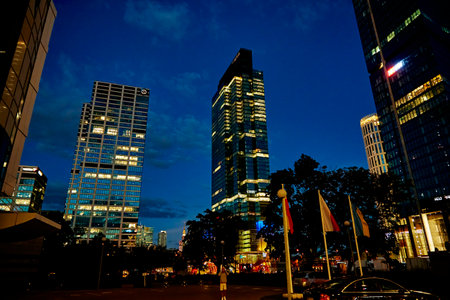 Office building facade with glowing lights in windows at night city. Warsaw city downtown district with skyscraper facade. Night city panorama. Warsaw, Poland - September 4, 2022のeditorial素材