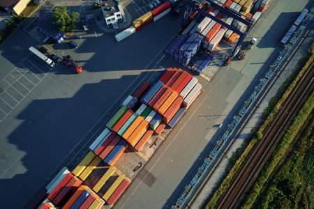 Shipping containers in terminal, Unloading containers in warehouse on railroad platform with cranes and forklifts, aerial viewの写真素材