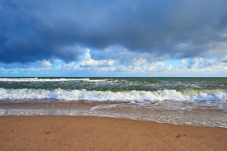 Sea coastline with waves at summer day. Baltic sea beach against beautiful cloudy sky. Panoramic...