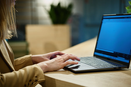 Female hands typing on laptop keyboard, close up. Woman using laptop in office. Online workの写真素材