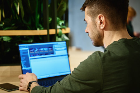 Male hands typing on laptop keyboard, close up. Man using laptop in office. Online work