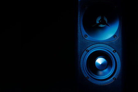 Multimedia acoustic sound speakers with blue neon lighting. Sound audio system on dark background with copy spaceの写真素材