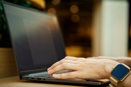 Hands typing on laptop keyboard. Close up shot of woman using laptop in cafeの写真素材