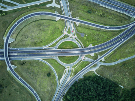 Aerial view of roundabout intersection with driving cars. Car traffic on highway with junction in...