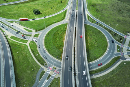 Aerial view of roundabout intersection with driving cars. Car traffic on highway with junction in Wroclaw, Poland. Rush hour in cityの写真素材