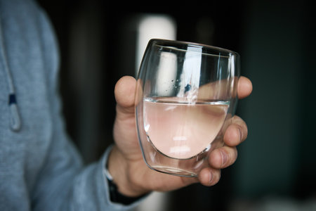 Man drinks water, Close-up shot of man holding glass of fresh water, Quenching thirst, Lifestyle healthcare conceptの写真素材